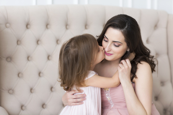 Young happy woman embrace with small daughter. Love and family concept  - Photo, Image