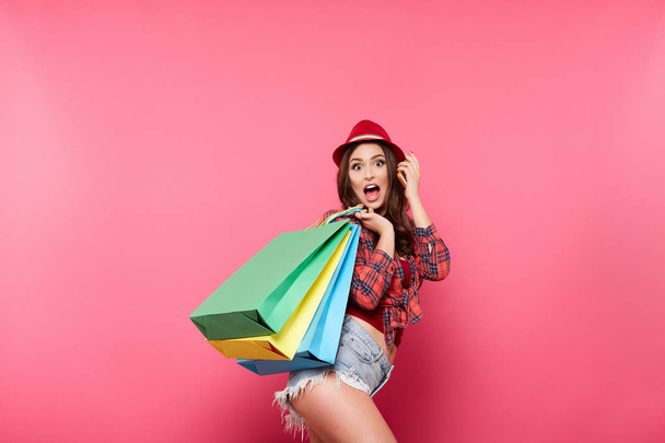 renkli alışveriş torbaları pembe arka plan, alışveriş ve indirim kavramı karşı poz olan kadın - Fotoğraf, Görsel