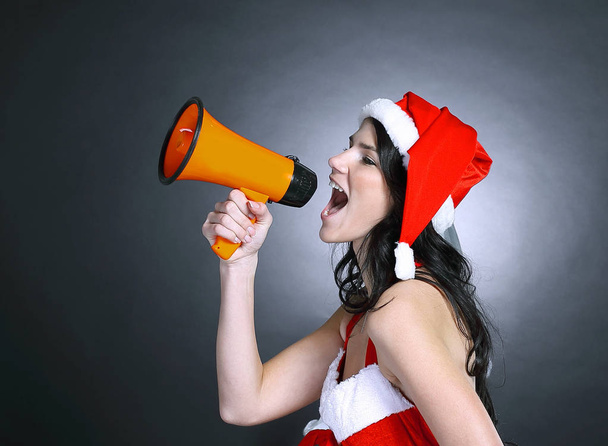 young woman dressed as Santa Claus shouting into a megaphone - Fotoğraf, Görsel