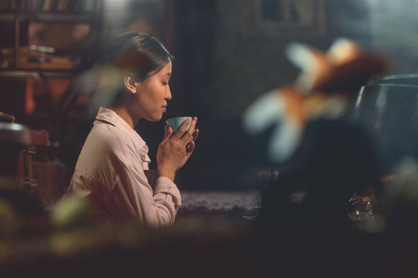 Молодая азиатка на чайной церемонии в комнате
 - Фото, изображение
