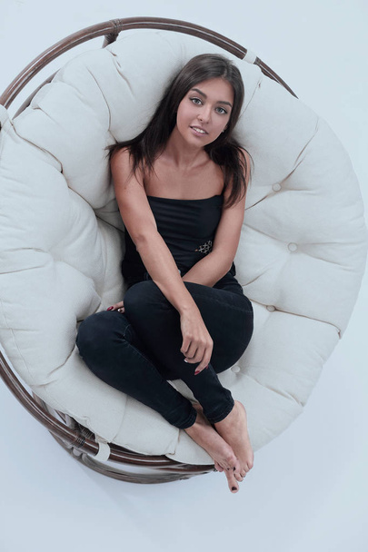 lachende jonge vrouw rusten in grote zachte fauteuil - Foto, afbeelding