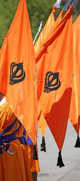 große orangefarbene Fahne mit dem Symbol des Sikhs namens Khanda während einer religiösen Zeremonie - Foto, Bild