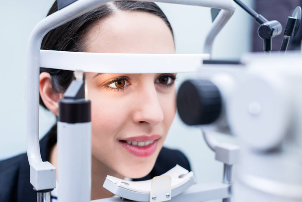 Woman having eyes measured with test device - Foto, Bild