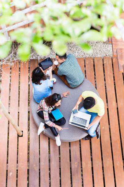 Empleados jóvenes que utilizan tecnología inalámbrica moderna mientras trabajan al aire libre
 - Foto, imagen