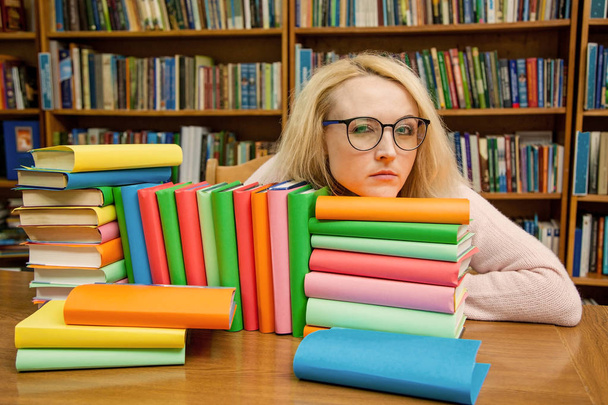 Девушка в библиотеке загадочным образом смотрит сквозь очки
 - Фото, изображение