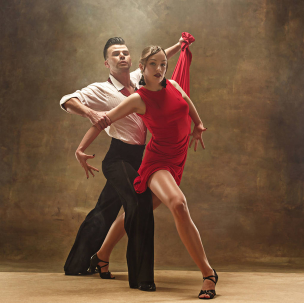 Flexible young modern dance couple posing in studio. - Fotó, kép