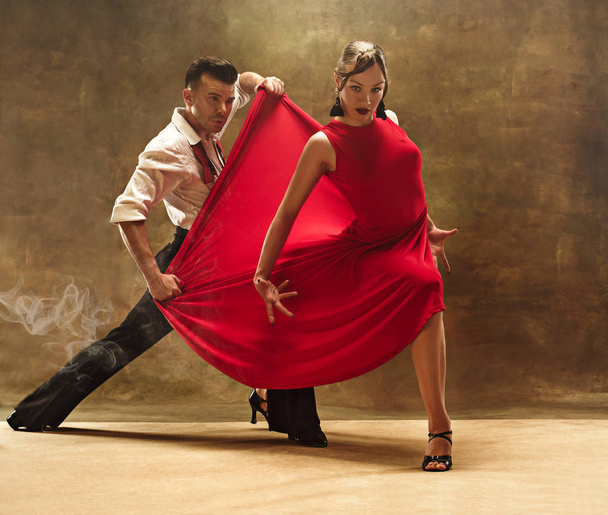 Flexible young modern dance couple posing in studio. - Фото, изображение