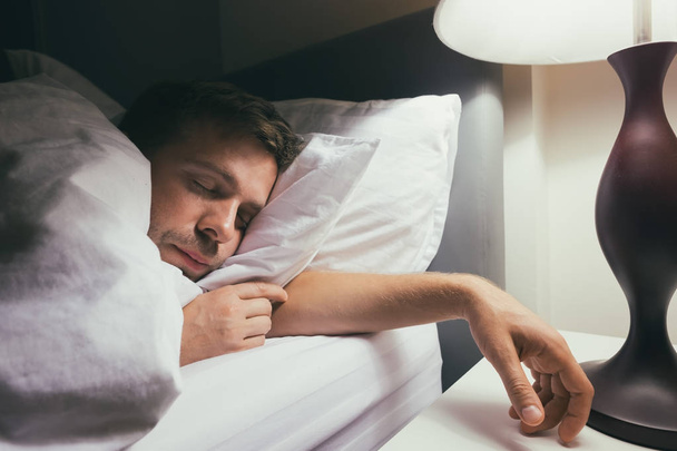 Handsome caucasian guy in bed sleeping home - Фото, изображение