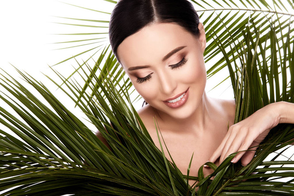 piękna kobieta stwarzających z tropikalnych palm liści na białym tle nad białym tle, koncepcja pielęgnacji skóry, skóra nawilżona - Zdjęcie, obraz