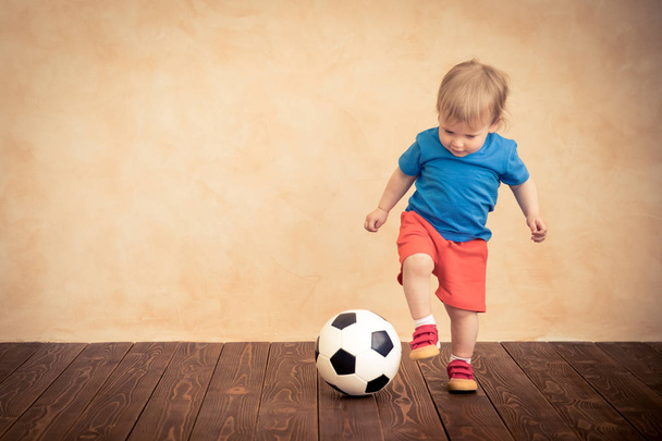 Lapsi teeskentelee olevansa jalkapalloilija. Menestyksen ja voittajan käsite
 - Valokuva, kuva