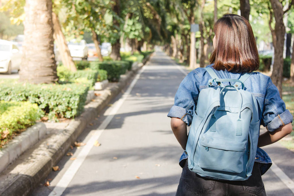 Summer lifestyle portrait of young tourist asian woman walking on the street, carry backpack. Travel tourist woman with backpack outdoors during holidays enjoying the view. Women lifestyle concept. - Foto, Bild