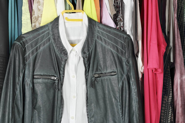 green leather jacket and white shirt in the closet - Fotó, kép