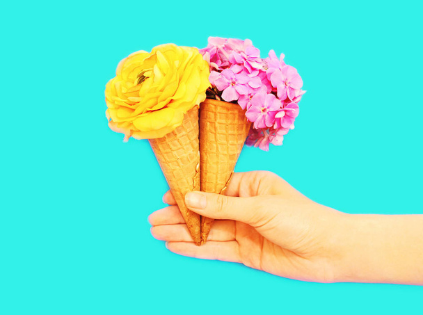 ice cream cone with flowers over blue background - Фото, изображение