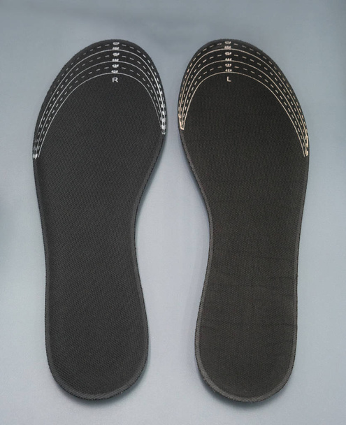 Ortesis sobre fondo gris. Insertar en los zapatos para apoyar el pie
 - Foto, Imagen