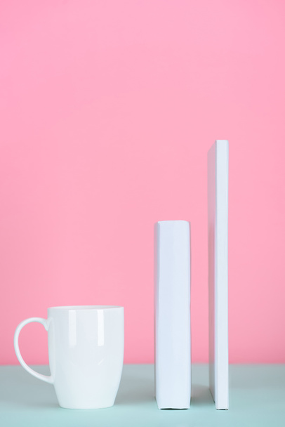 white books and cup of tea on table on pink - Foto, immagini
