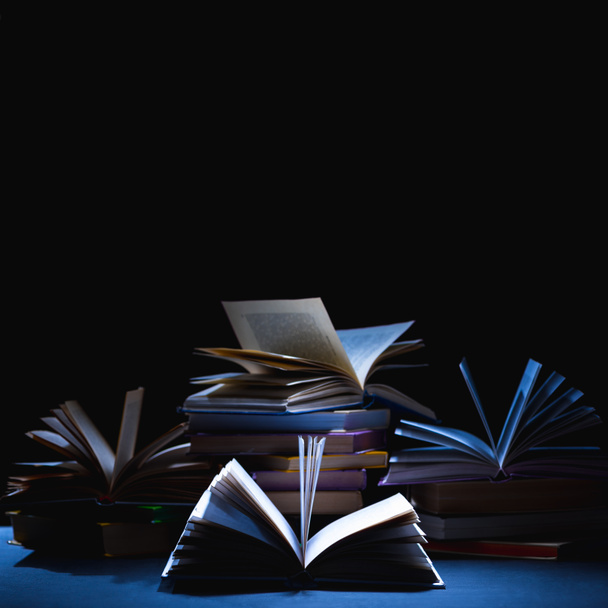 pila de diferentes libros en la mesa oscura en negro
 - Foto, imagen