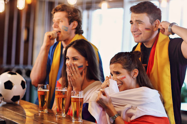 Groupe d'amis regardant le football dans un pub
 - Photo, image