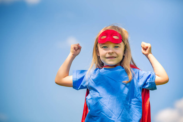 Funny little girl playing power super hero. - Фото, изображение