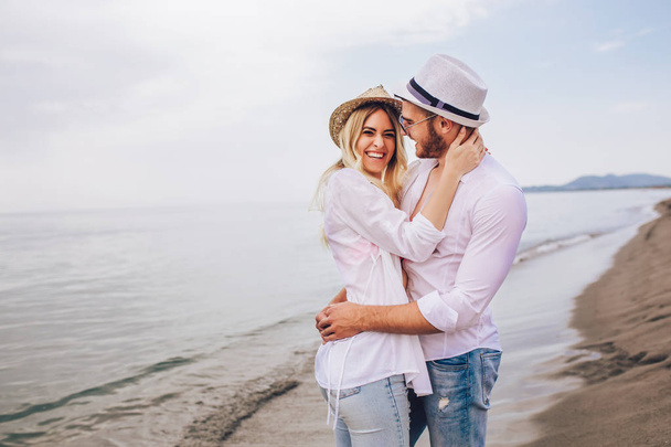 Ρομαντικό ζευγάρι έχει τη διασκέδαση στην παραλία το ηλιοβασίλεμα - Φωτογραφία, εικόνα