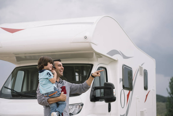 Pai e filho com a caravana de férias
 - Foto, Imagem