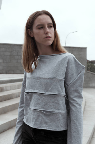 stilvolles Mädchen in konzeptioneller Designer-Kleidung vor urbanem Hintergrund - Foto, Bild