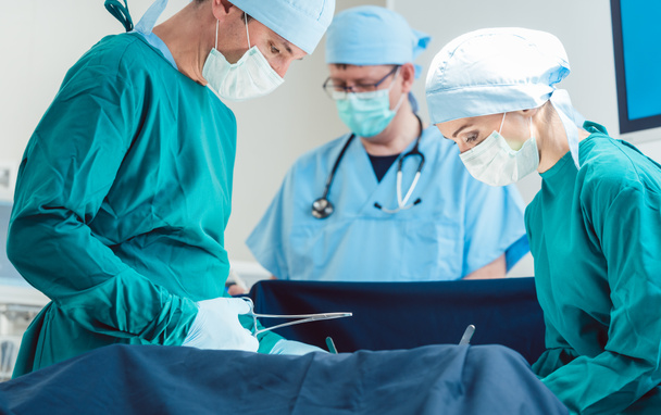 Chirurgische arts in volle concentratie op de operatie - Foto, afbeelding