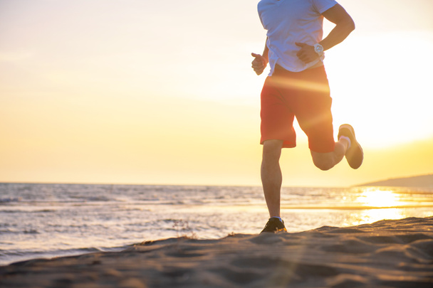 Вид человека, бегущего по пляжу на закате
 - Фото, изображение