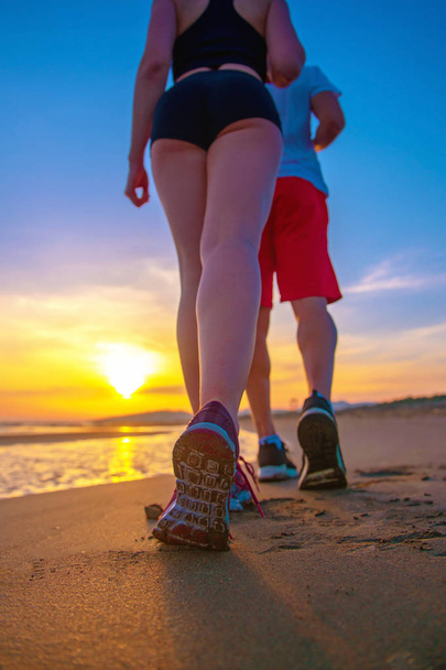 Нижняя низкая секция вид на пару пешком по пляжу
 - Фото, изображение