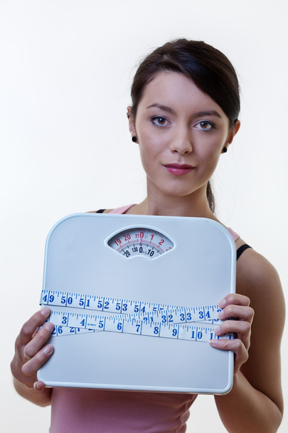 posing sporty woman with scale and tape measure - Photo, Image