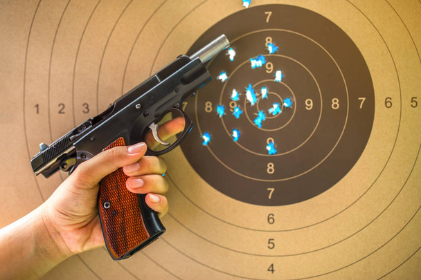Pistolet de 9 mm sur cible bullseye pour la pratique du tir. - Photo, image