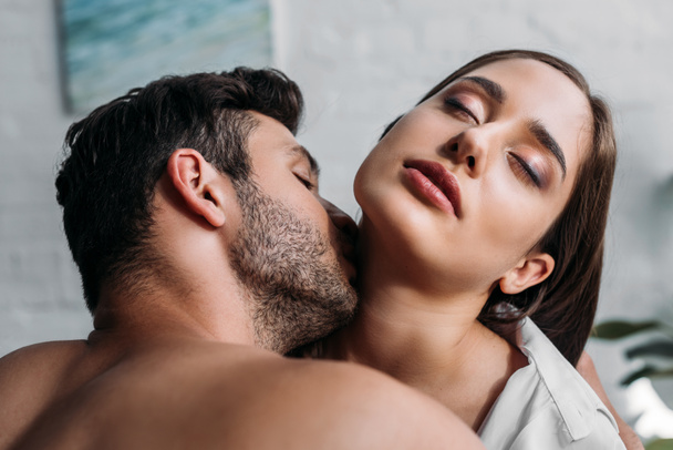 boyfriend kissing sensual girlfriends neck in bedroom in morning - Photo, Image