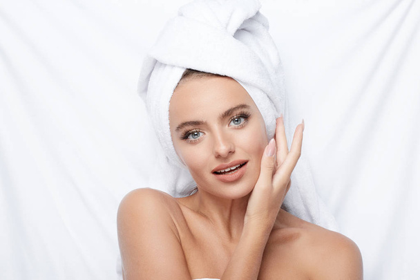 mooie en natuurlijke jonge vrouw met tulband handdoek op hoofd, huidverzorging, gehydrateerd huid, behandeling concept  - Foto, afbeelding