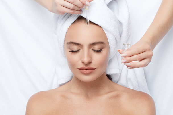 jeune femme avec une peau parfaite ayant massage facial, mains sur le visage, soins de la peau, procédure de spa et concept relaxant
  - Photo, image