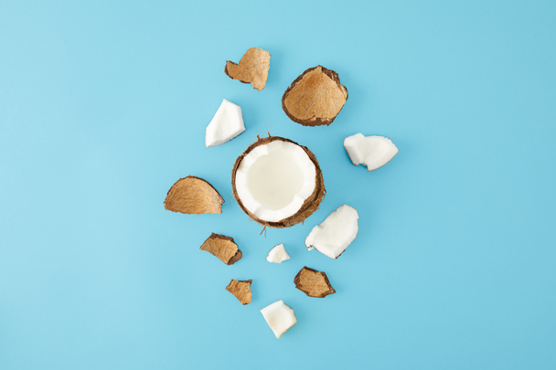 bovenaanzicht van gearrangeerde kokosnoot stukken geïsoleerd op blauw - Foto, afbeelding
