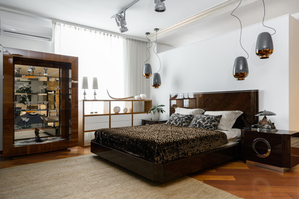 belső tér modern világos hálószoba lámpa, polcok és barna ágynemű - Fotó, kép