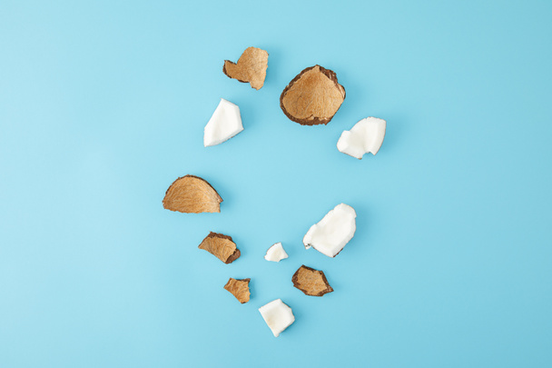top view of arranged coconut pieces isolated on blue - Photo, Image