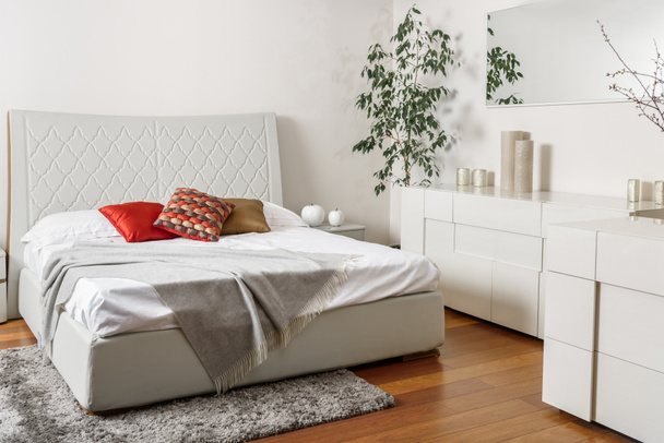 interior de dormitorio de luz moderna con almohadas de colores en la cama
 - Foto, imagen