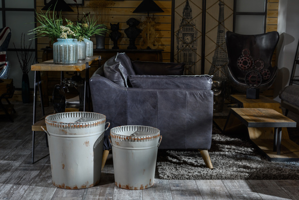 интерьер современной гостиной в стиле ретро с серым креслом и мусорными баками
 - Фото, изображение