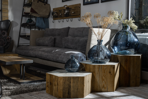 interno di moderno soggiorno in stile retrò con divano grigio e vasi su ripiani in legno
 - Foto, immagini