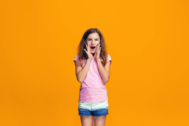 Isolated on yellow young casual teen girl shouting at studio - Фото, зображення