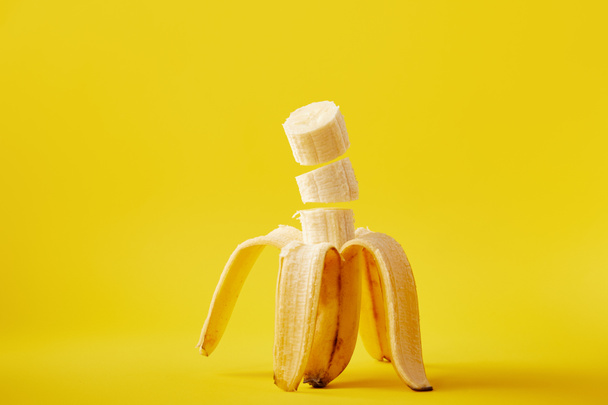 close up view of ripe cut banana isolated on yellow - Valokuva, kuva