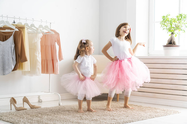 Happy girls dressing up at home. Funny lovely children are having fun in room. - Fotó, kép