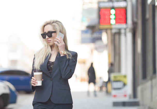 Successful businesswoman with cellphone while walking outdoor. City business woman working. - Fotoğraf, Görsel