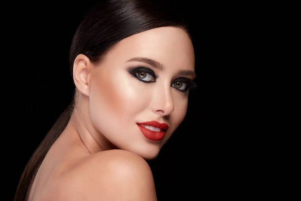 portrait de belle jeune femme avec maquillage lumineux posant sur fond noir studio, faux cils
 - Photo, image