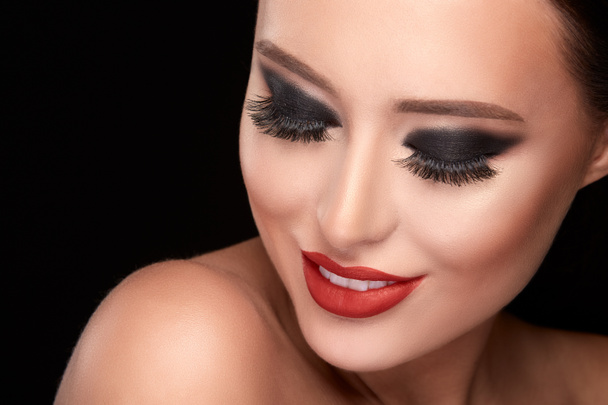 portrait of beautiful young woman with bright make up posing against black studio background, fake eyelashes - Zdjęcie, obraz