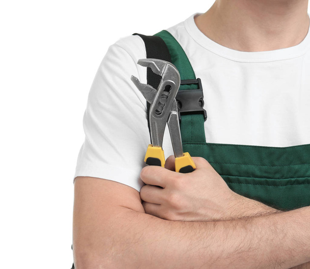Young plumber with adjustable wrench on white background, closeup - Zdjęcie, obraz