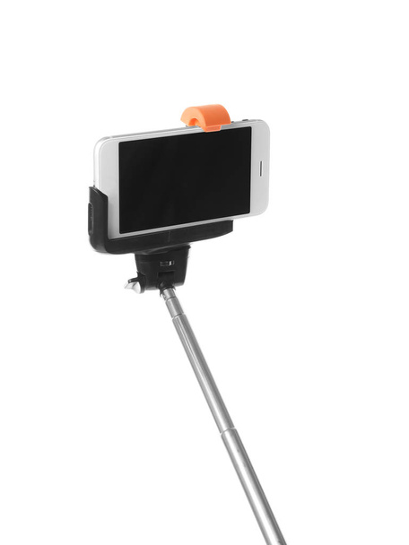 Selfie stick with mobile phone on white background - Photo, image