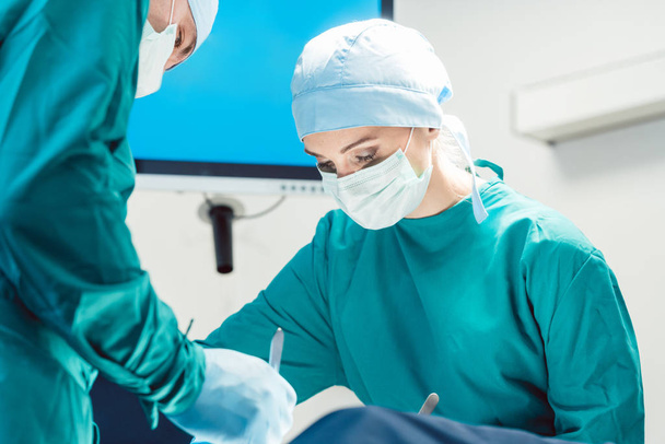 Kirurgit leikkaussalissa leikkauksen aikana
 - Valokuva, kuva