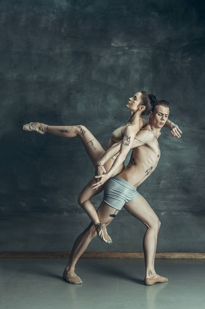 The young modern ballet dancers posing on gray studio background - Foto, afbeelding