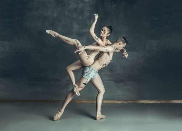 The young modern ballet dancers posing on gray studio background - Фото, зображення